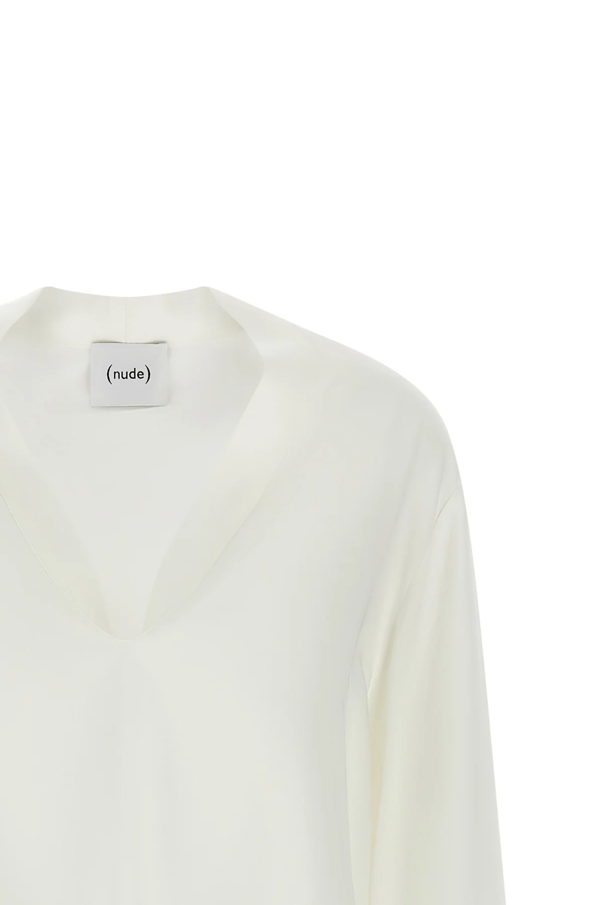 the nude blouse is distinguished by a fluid and deconstructed silhouette