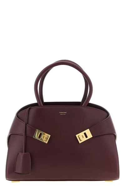 ferragamos hug (m) handbag in fine burgundy hammered calf leather stands out