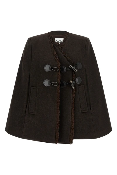 the ganni cape redefines the volumes of the outerwear through a flared and envel