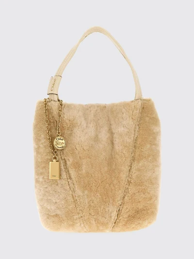 chloé spin shearling shoulder bag with double handle and decorative charm